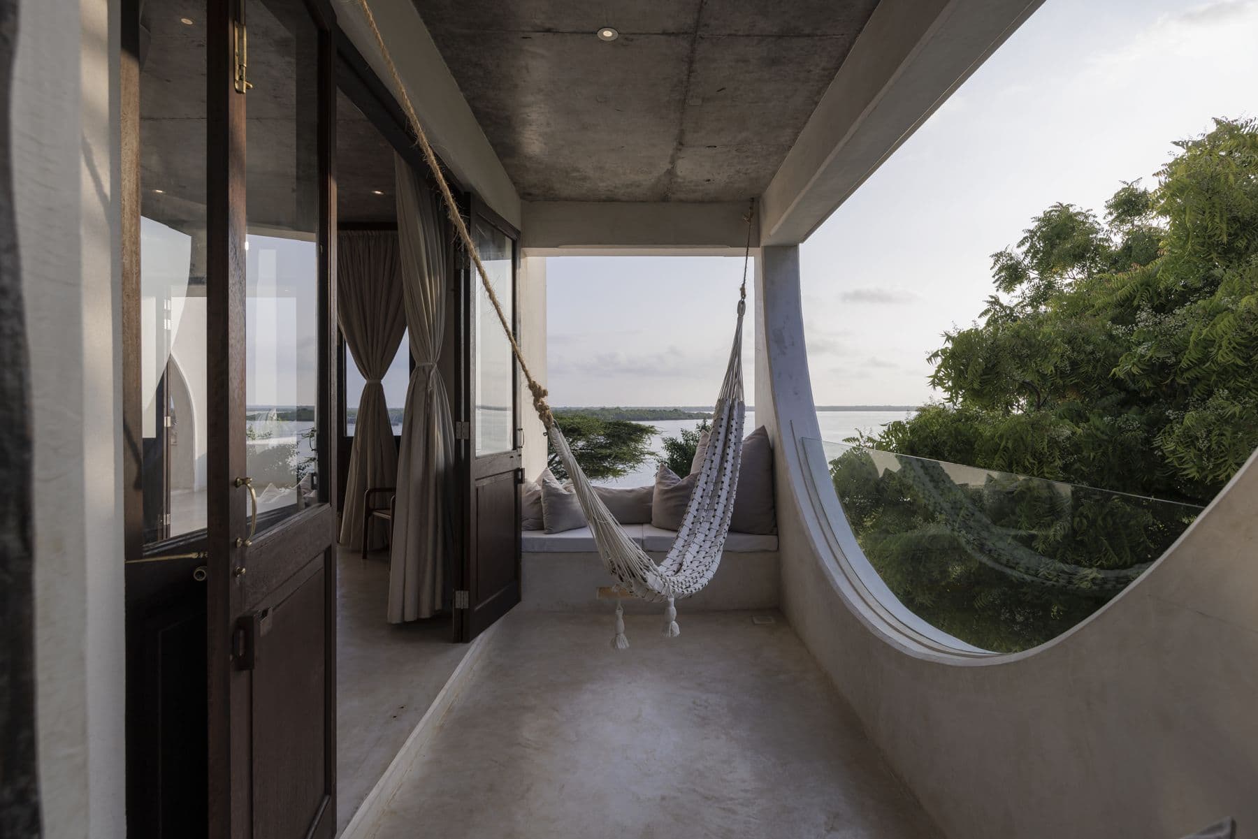 A hammock on a suite balcony at sunrise